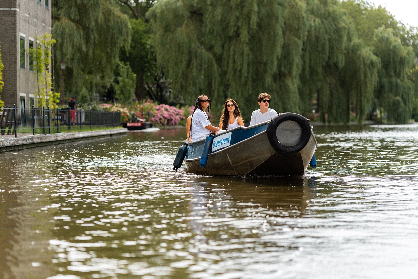 Amigos disfrutando de un paseo en barco por los canales de Ámsterdam – ideal como regalo